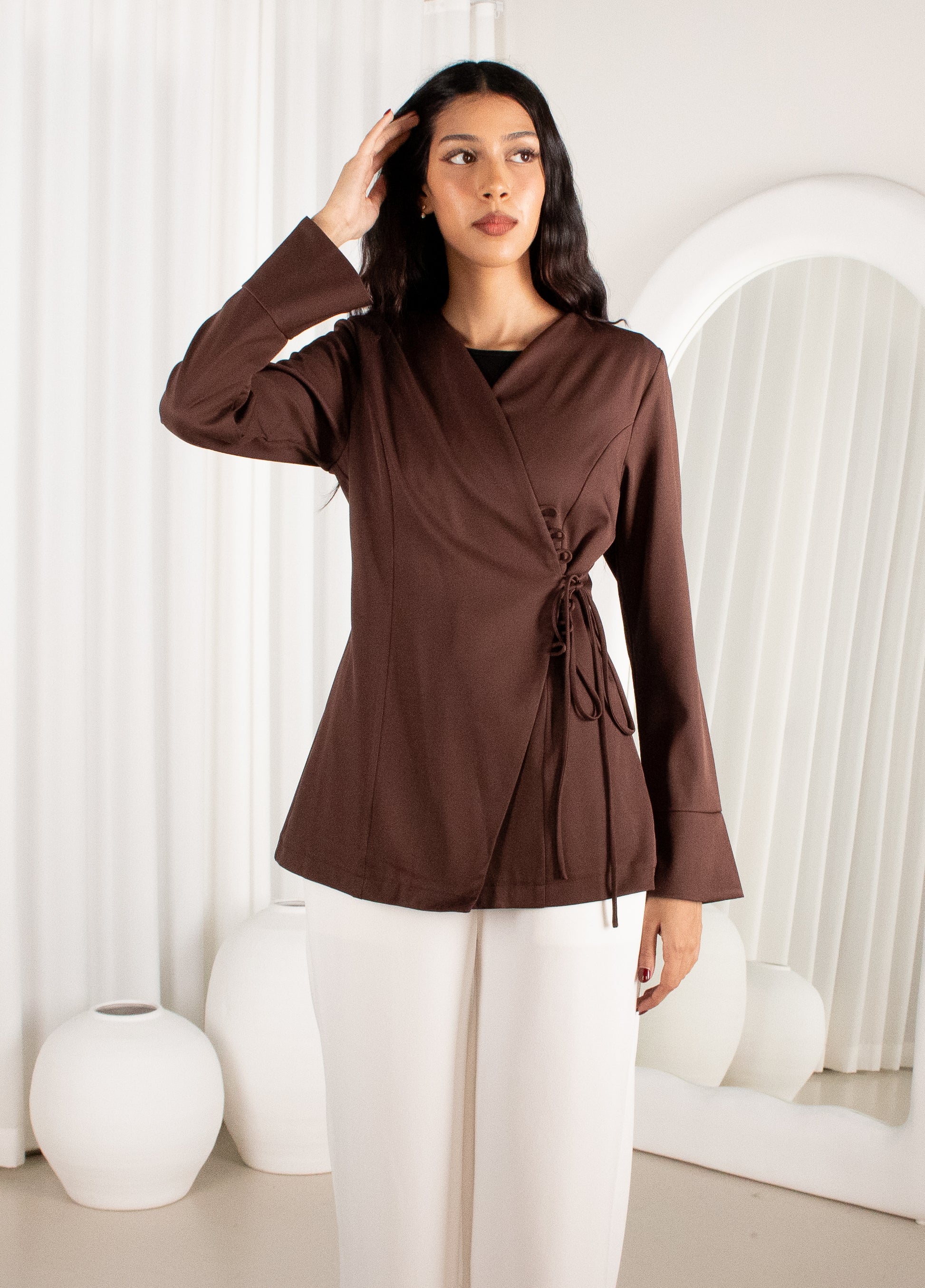 Woman wearing a brown top with a white background