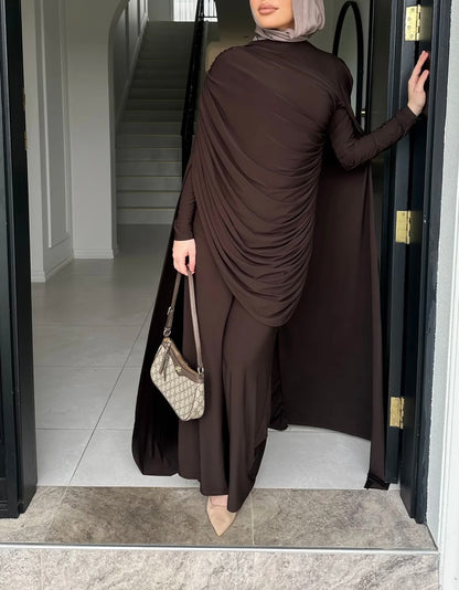 Person wearing a long brown dress entering a building.