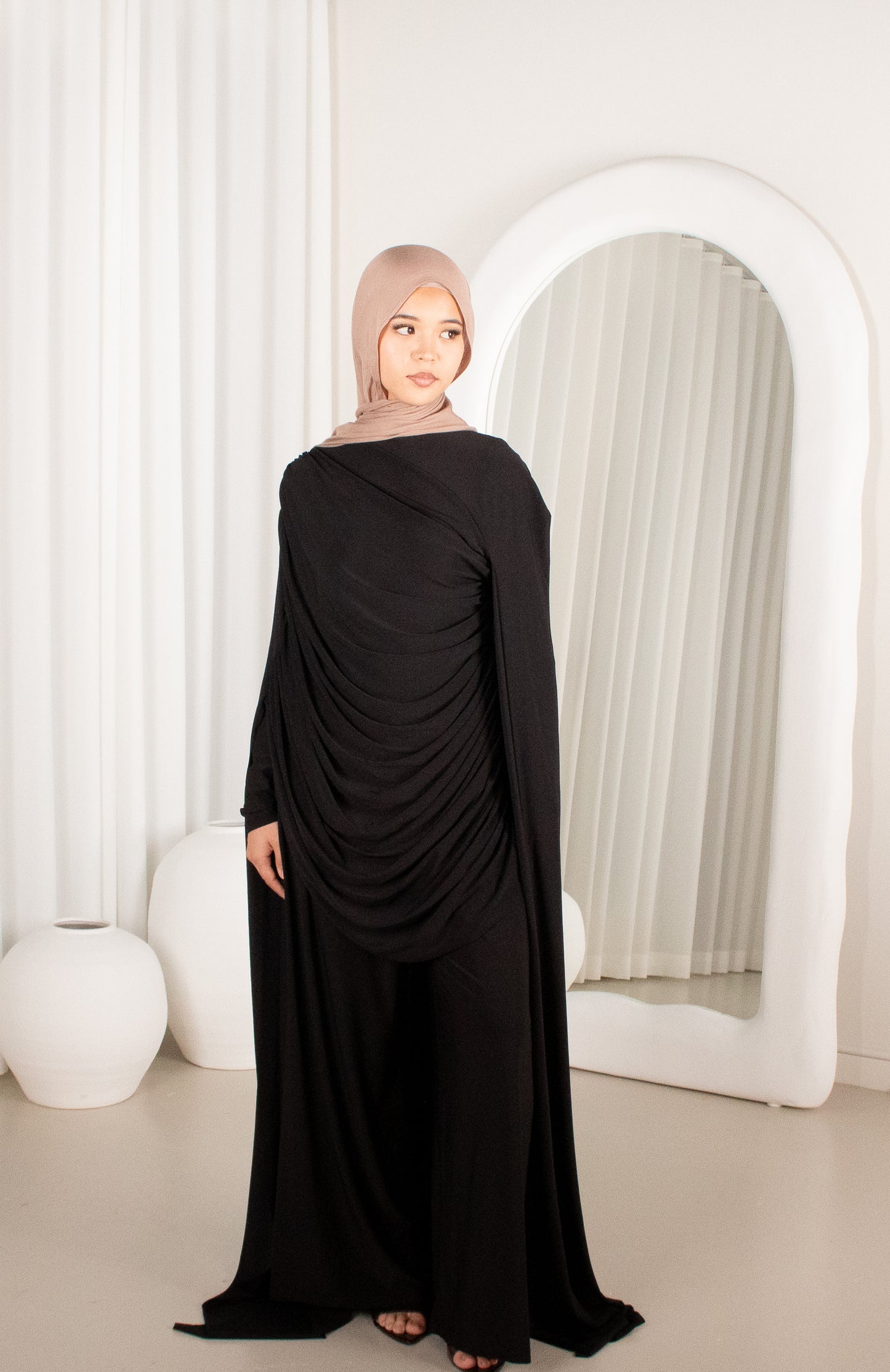 Woman wearing a black dress with a beige hijab