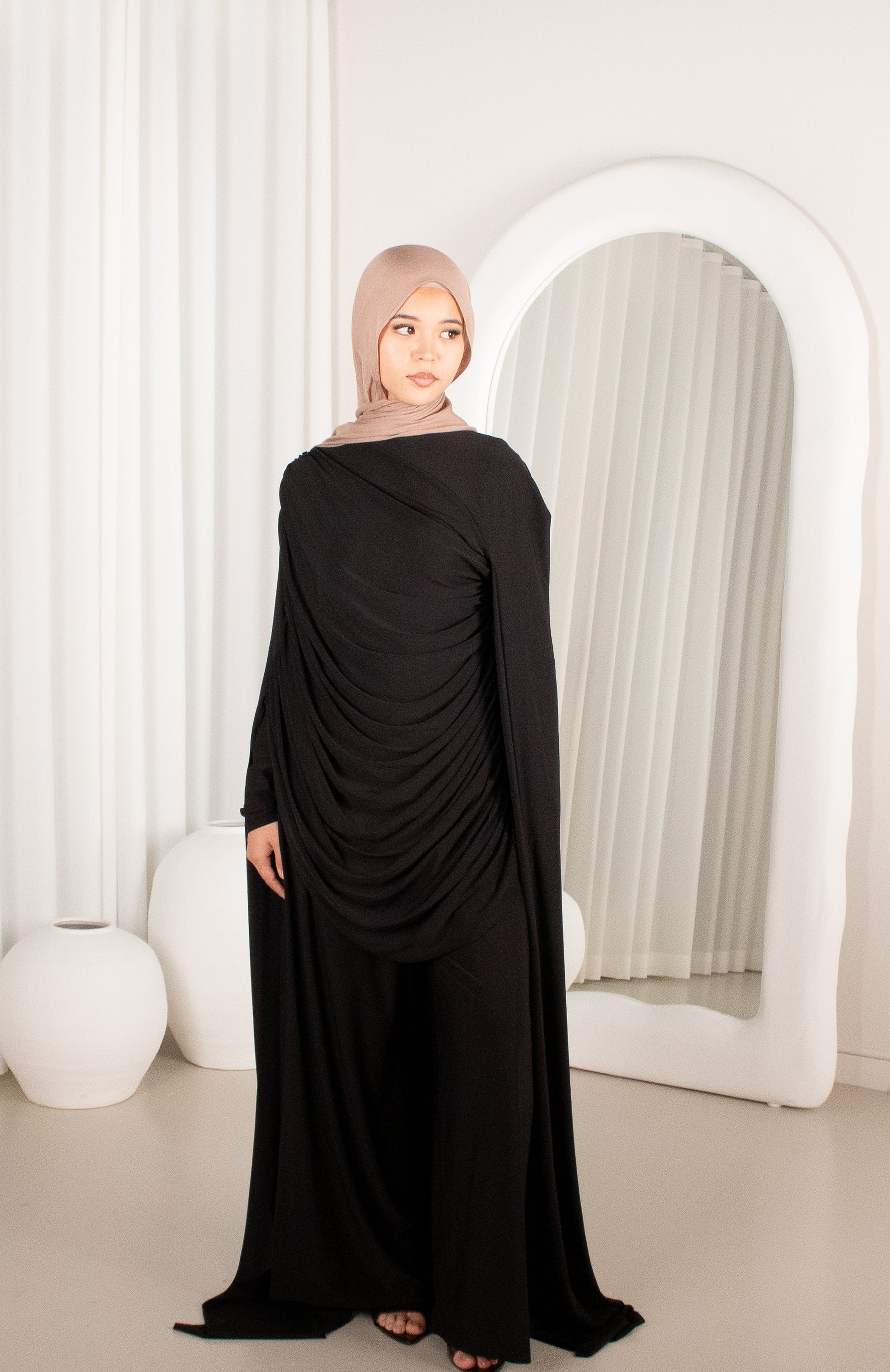 Woman wearing a black dress with a beige hijab